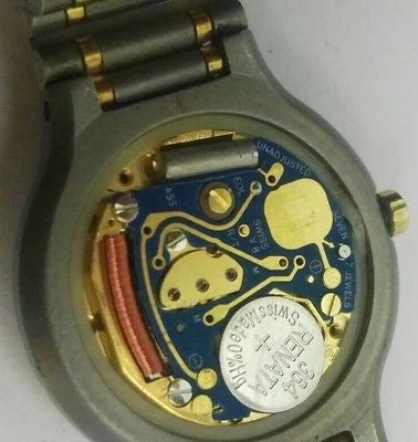 Watch movement visible through caseback showing balance wheel and mechanical parts