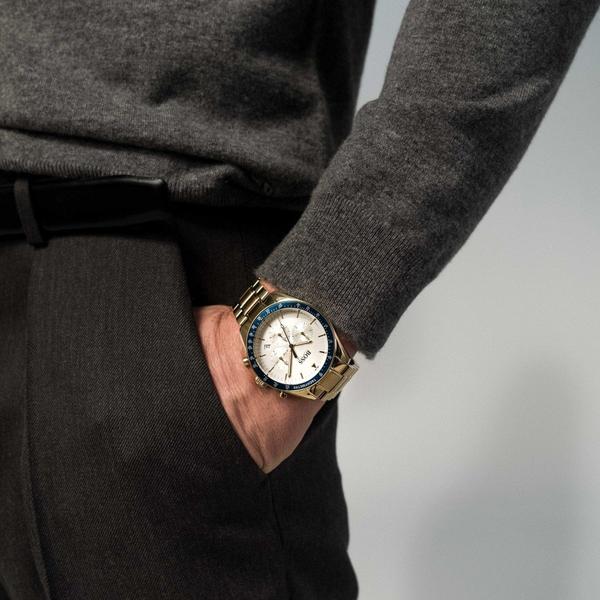 Trophy chronograph watch on wrist showing chronograph subdials and gold bracelet