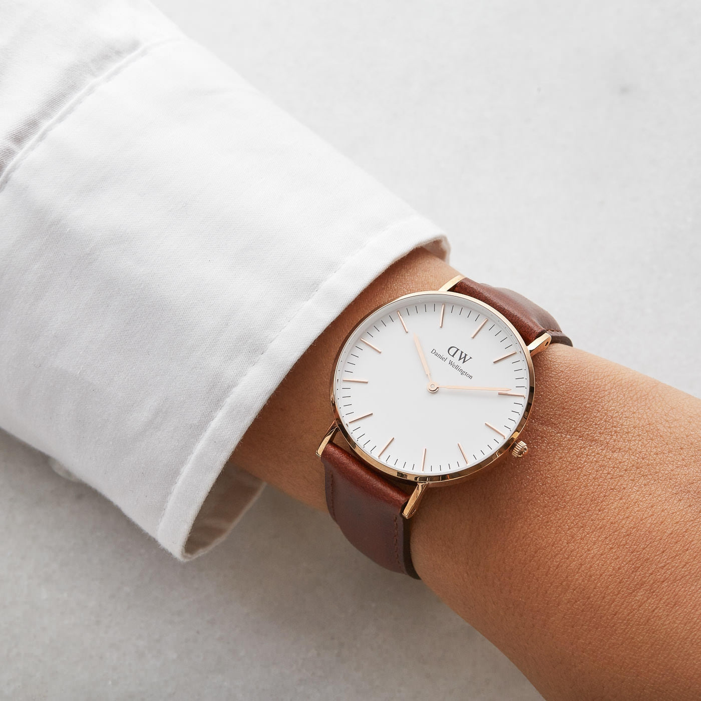Daniel Wellington St Mawes watch worn on wrist with white dial and gold case detail