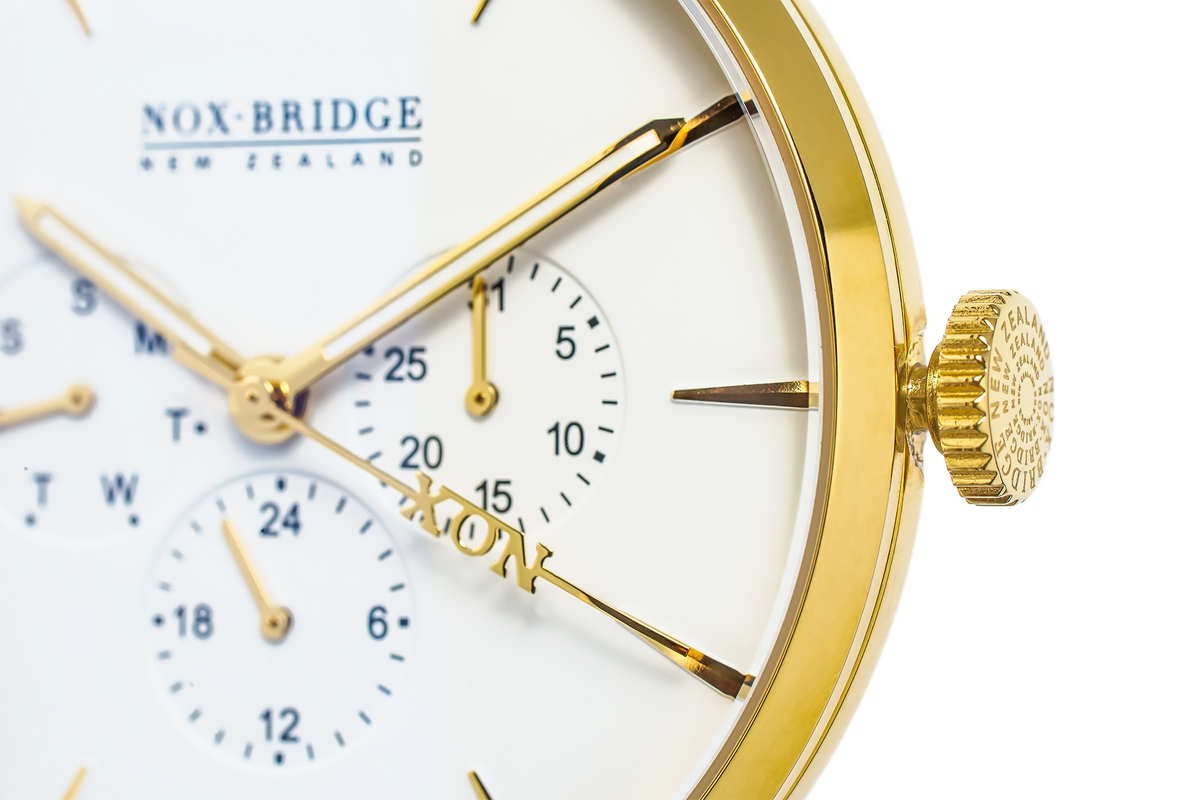 Close-up of Alcyone gold case, white dial with chronograph subdials and Noxbridge branding